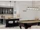 Finished basement wet bar, pendant lights, bar seating, pool table and modern light fixture at 1332 S Lafayette St, Denver, CO 80210