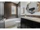 Bathroom with shower-tub combo, dark tile accent wall, and decorative vanity mirror at 1332 S Lafayette St, Denver, CO 80210