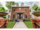 Elegant brick facade with manicured lawn and decorative planters, showcasing a beautiful property at 1332 S Lafayette St, Denver, CO 80210
