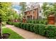 Charming home with brick and black iron fence surrounded by lush greenery and mature trees at 1332 S Lafayette St, Denver, CO 80210