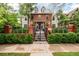 Stately brick home featuring manicured landscaping, black iron fence, and an inviting entrance at 1332 S Lafayette St, Denver, CO 80210