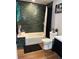 Clean bathroom with dark green tile and a bathtub at 3736 S Lincoln St, Englewood, CO 80113