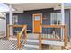 Inviting front porch with wooden railings, orange door at 3736 S Lincoln St, Englewood, CO 80113