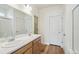 Bathroom with double sinks, wood cabinets, and a tiled shower at 1546 Farmstead St, Brighton, CO 80601