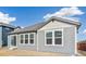 Gray siding home with three windows and sliding glass door at 1546 Farmstead St, Brighton, CO 80601