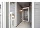 Front entry with gray siding, a dark door, and white trim at 1546 Farmstead St, Brighton, CO 80601