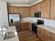 Modern kitchen with stainless steel appliances and light wood cabinets at 1546 Farmstead St, Brighton, CO 80601