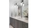 Bright bathroom featuring double sinks, modern lighting, and a glimpse into the tiled shower area at 1750 Wewatta St # 809, Denver, CO 80202