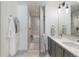 Modern bathroom features double sinks, a shower, and tub with marble-look tiles and white and gray accents at 1750 Wewatta St # 809, Denver, CO 80202