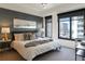 Serene bedroom with large windows, city views, and stylish decor with lamps and artwork at 1750 Wewatta St # 809, Denver, CO 80202