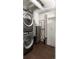 Practical laundry area with stacked washer/dryer and added storage. Industrial elements and neutral tiling throughout at 1750 Wewatta St # 809, Denver, CO 80202