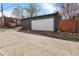 Detached garage with white door and paved driveway provides convenient parking and storage at 2207 E 25Th, Denver, CO 80205