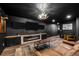 Finished basement with a modern fireplace, multiple screens, and rustic chandelier at 5795 S Pagosa Way, Centennial, CO 80015