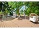 Charming outdoor fireplace area with a cozy wicker chair and a well-maintained wooden deck at 5795 S Pagosa Way, Centennial, CO 80015