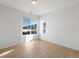 Bright, empty bedroom with light wood floors and large windows showing the outside buildings at 6153 N Ceylon St # 307, Denver, CO 80249
