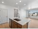 Open kitchen with white walls, wood flooring, and an island with a sink and white countertop at 6153 N Ceylon St # 307, Denver, CO 80249