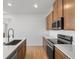 Modern kitchen featuring stainless steel appliances, wooden cabinets, and a spacious countertop at 6153 N Ceylon St # 307, Denver, CO 80249