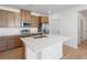 Bright kitchen showcasing wooden cabinets, stainless steel appliances, and a spacious island with a sink at 6153 N Ceylon St # 307, Denver, CO 80249