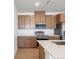 Well-lit kitchen with stainless steel oven and microwave, complemented by wooden cabinets and white countertops at 6153 N Ceylon St # 307, Denver, CO 80249