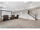 Finished basement with carpeted flooring, a theater seating area, and a staircase at 16227 Pikes Peak Dr, Broomfield, CO 80023