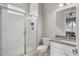 Modern bathroom featuring a glass-enclosed shower with white tile and a gray vanity with white cabinets at 16227 Pikes Peak Dr, Broomfield, CO 80023