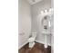 A classic half bathroom featuring a pedestal sink, toilet and hardwood flooring at 16227 Pikes Peak Dr, Broomfield, CO 80023