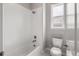 Bright white bathroom features a tiled shower/tub, a white toilet, and a window to allow for natural light at 16227 Pikes Peak Dr, Broomfield, CO 80023