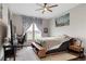 Comfortable bedroom with a ceiling fan, a large window with patterned curtains, and a workspace at 16227 Pikes Peak Dr, Broomfield, CO 80023
