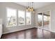A dining area is brightened by large windows and features a modern chandelier and wood floors at 16227 Pikes Peak Dr, Broomfield, CO 80023