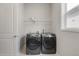 A functional laundry room with a side by side washer and dryer, window and a wire rack for storage at 16227 Pikes Peak Dr, Broomfield, CO 80023