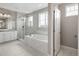 A modern bathroom showcases a glass shower, soaking tub, double vanity sinks, and tile flooring at 16227 Pikes Peak Dr, Broomfield, CO 80023