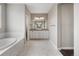 An elegant bathroom with marble flooring, soaking tub, double vanity sinks and modern lighting at 16227 Pikes Peak Dr, Broomfield, CO 80023