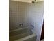 Bathroom with tiled walls surrounding a bathtub and shower head at 9062 Utica St, Westminster, CO 80031