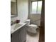 Updated bathroom featuring modern vanity, toilet, grab bar, frosted window and neutral colors at 9062 Utica St, Westminster, CO 80031
