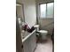 Compact bathroom with light gray vanity, white toilet, and grab bars for accessibility at 9062 Utica St, Westminster, CO 80031
