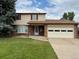 Charming two-story home featuring a brick and siding exterior, attached garage, and well-maintained front yard at 9062 Utica St, Westminster, CO 80031