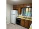 A kitchen featuring wood cabinets, neutral countertops, and a white refrigerator at 9062 Utica St, Westminster, CO 80031