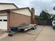 View of the home's side exterior, including a brick chimney, a section of the backyard fence, and the driveway at 9062 Utica St, Westminster, CO 80031