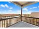 Balcony view with wood railing of the neighborhood and plains beyond under a sunny sky at 10723 N Montane Dr, Broomfield, CO 80021