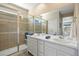 Bathroom featuring a double vanity and a glass-enclosed shower with decorative tile at 10723 N Montane Dr, Broomfield, CO 80021