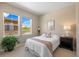 Bright bedroom with two windows, a bed with colorful bedding, and a black nightstand at 10723 N Montane Dr, Broomfield, CO 80021