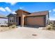Charming exterior view of home with a two-car garage, stone accents, and blue and tan siding at 10723 N Montane Dr, Broomfield, CO 80021