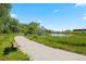 Picturesque view of a pond along a walking path with a bench, surrounded by lush vegetation at 10723 N Montane Dr, Broomfield, CO 80021