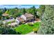 Sprawling backyard with mature trees and a patio providing an ideal setting for relaxing and entertaining at 3850 S Willow Way, Denver, CO 80237