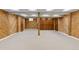 Spacious basement featuring wood paneling, plush carpeting, and ample storage space, ideal for recreation or hobbies at 3850 S Willow Way, Denver, CO 80237