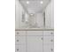 Bathroom with granite counters, white cabinets, and a large mirror with recessed lighting and a modern faucet at 3850 S Willow Way, Denver, CO 80237