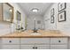 Bathroom with a white shower, granite counters, white cabinets and a large mirror with gold trim at 3850 S Willow Way, Denver, CO 80237