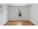 Empty bedroom with hardwood floors and a bright window overlooking trees and other vegetation at 3850 S Willow Way, Denver, CO 80237