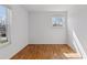 Empty bedroom with hardwood floors and a bright window overlooking trees and other vegetation at 3850 S Willow Way, Denver, CO 80237