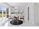 Bright dining area with large windows, a stylish table, and an open view into the kitchen at 3850 S Willow Way, Denver, CO 80237